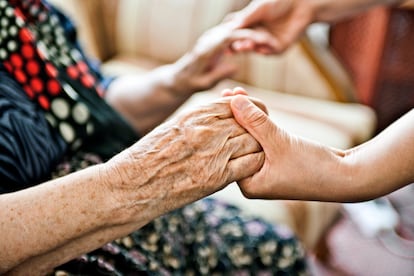 A young woman greets an elderly woman.