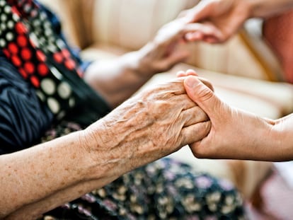 Una mujer joven saluda a una anciana.