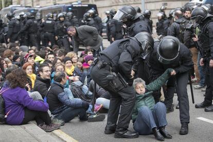 Agentes de los Mossos d'Esquadra desalojan a un grupo de personas que han cortado la calle de entrada el Tribunal Superior de Justicia de Cataluña.