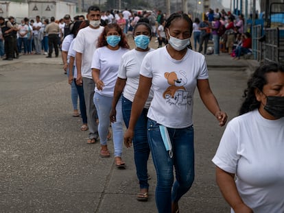 Familiares de las personas privadas de libertad hacen fila para ingresar a la Penitenciaría del Litoral, mientras agentes policiales verifican sus datos personales y los de la persona a visitar, en Guayaquil el 17 de julio.