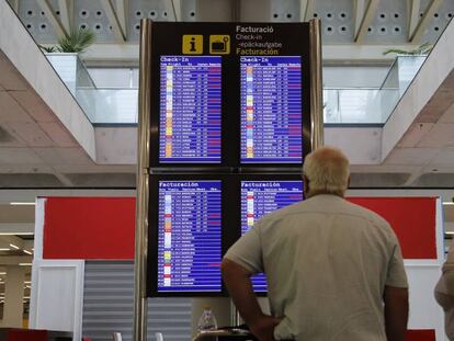 Pasajeros consultando vuelos en el aeropuerto de Palma de Mallorca.