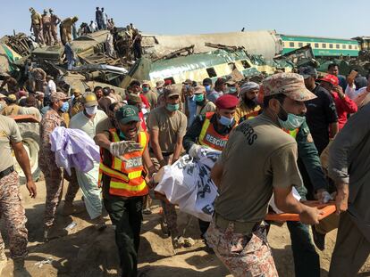 Membros das equipes de resgates sobre o teto de um dos vagões acidentados no choque entre dois trens na província paquistanesa de Sindh, nesta segunda-feira.