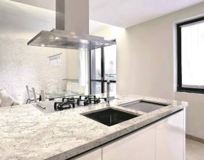 Isla con cocina, fregadero y encimera de granito Warwick Pearl.