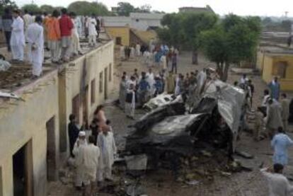 Paquistaníes inspeccionan los restos del avión accidentado cerca de Islamabad, Pakistán. EFE/Archivo