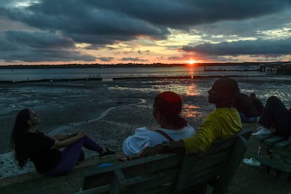 La gente mira la puesta de sol en el puerto de Buenaventura, el 6 de septiembre de 2022.