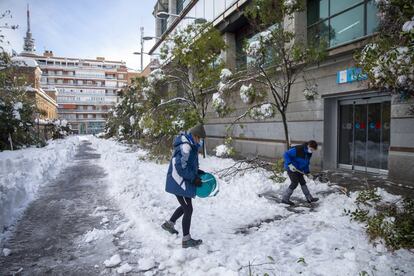 Varios voluntarios despejan con palas el acceso a una de las entradas del Hospital Gregorio Marañon de Madrid, cubierto de una gruesa capa de nieve tras el paso de la borrasca Filomena, este domingo.