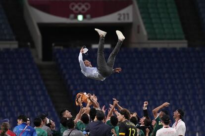 Los jugadores de la selección de fútbol de México celebran el bronce conseguido frente a Japón aupando a su entrenador, Jaime Lozano.