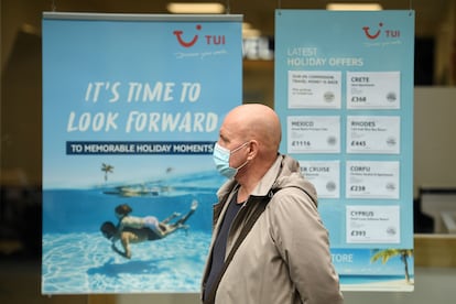 Un hombre con mascarilla pasa ante un anuncio de TUI en Liverpool (Reino Unido), el pasado 2 de octubre,