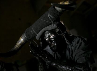 Un hombre se prepara para la celebración de los 'Diablos de Luzón' durante las fiesta de carnaval. Los participantes se cubren de aceite y hollín y portan cuernos de toro como representación del diablo, el 4 de marzo.