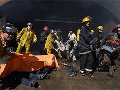 Los bomberos rescatan a las víctimas del incendio en el centro comercial Ikuá Bolaños, a las afueras de Asunción.