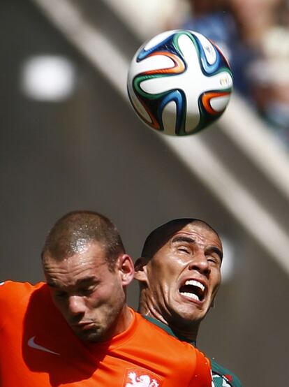Sneijder (i) y Salcido saltan por el balón.