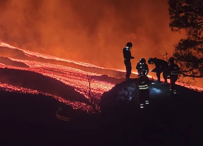 Cinco miembros de la Unidad Militar de Emergencias recogen muestras de lava en el volcán de La Palma.