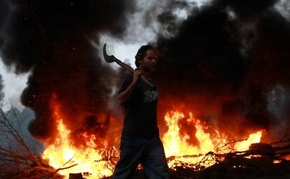 Un miembro de el Movimiento de Trabajadores Sin Hogar de Brasil junto a una barricada en una carretera de Rio Grande do Sul.