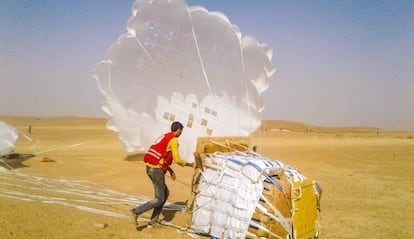 La Media Luna Roja Árabe Siria recibe en tierra alimentos y otros suministros humanitarios lanzados por el PMA desde gran altura sobre Deir Ezzor, en Siria.