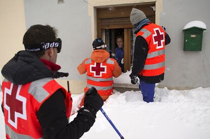 Miembros de la Cruz Roja llevan comida y medicinas a una vecina de Barruelo de Santullán (Palencia), atrapada por la nieve.