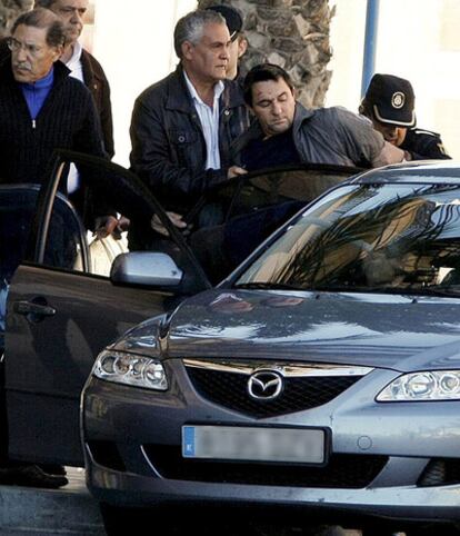 La policía introduce en un coche al hombre que atracó ayer un banco en Alicante.