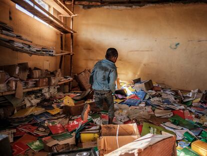 Un niño camina entre libros en la biblioteca de una antigua escuela primaria que resultó dañada durante los enfrentamientos que estallaron en la región de Tigray en Etiopía, en el pueblo de Bisober, el 9 de diciembre de 2020.