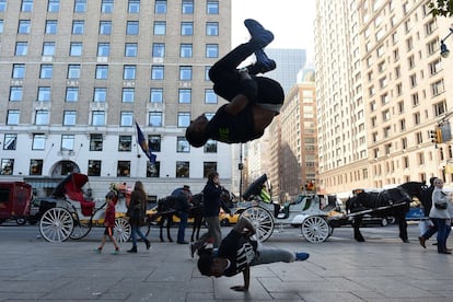 Bailarines callejeros de 'break dance' realizan piruetas cerca de Central Park, en Nueva York.