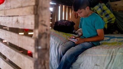 César Correa (9) juega con el teléfono de su madre, en el corregimiento de San Sebastián de Palmitas, en noviembre.