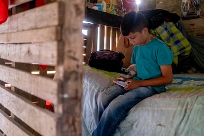 César Correa (9) juega con el teléfono de su madre, en el corregimiento de San Sebastián de Palmitas, en noviembre.