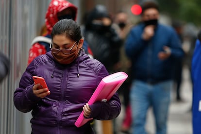 Una mujer consulta su teléfono móvil mientras anda por Santiago de Chile.