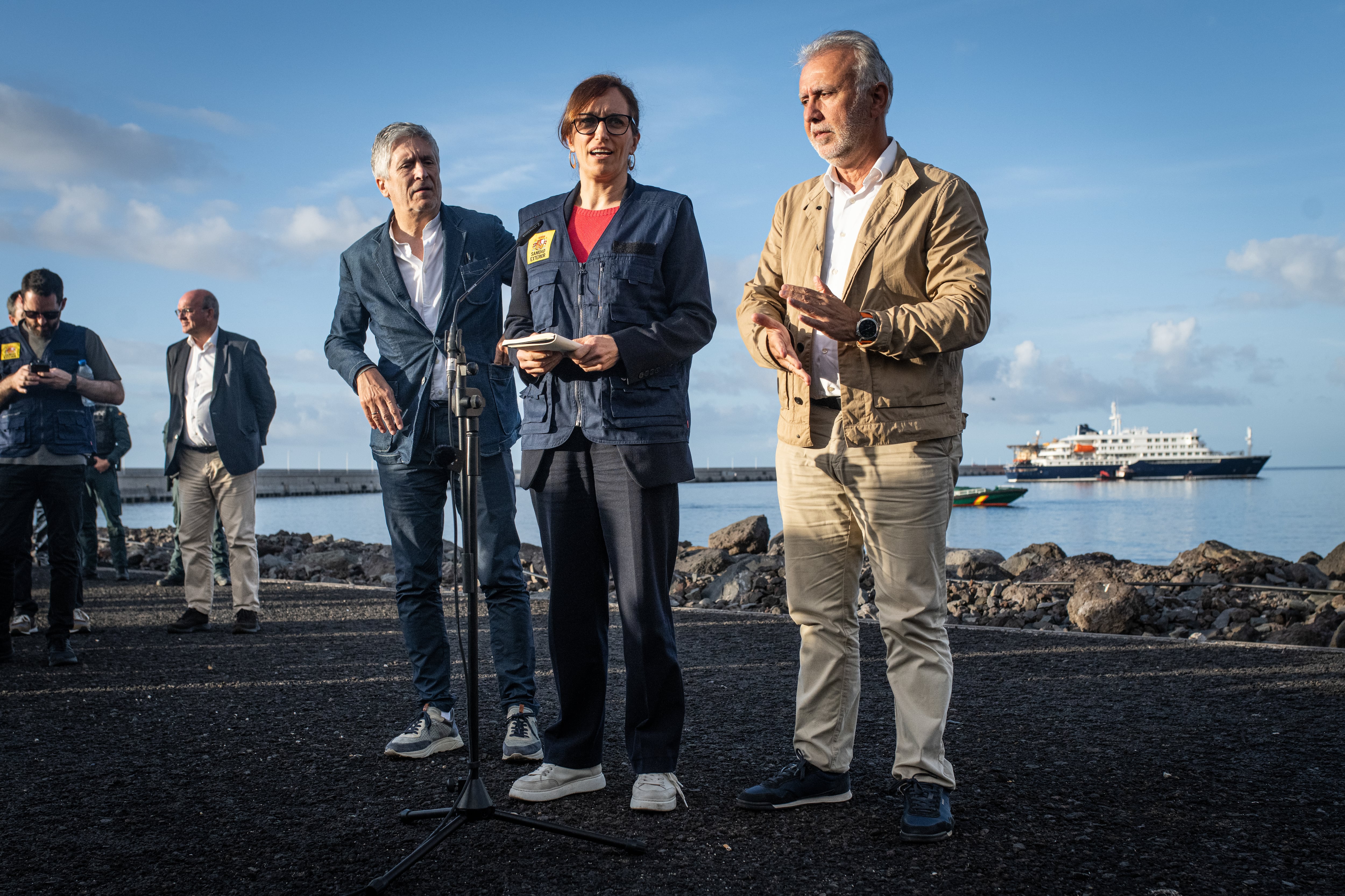 La ministra de Sanidad Mónica García, el ministro de Interior, Fernando Grande-Marlaska, y el titular de Política Territorial y Memoria Democrática, Ángel Víctor Torres, este domingo en el Puerto de Granadilla, con el crucero 'MV Hondius' de fondo. 