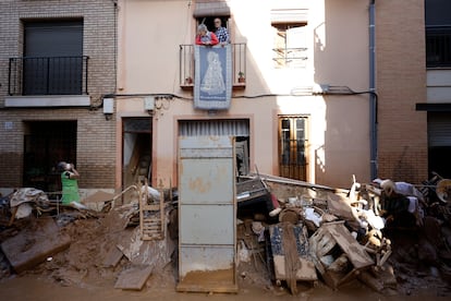 Un vecina habla desde su ventana al no poder salir de su vivienda por el bloqueo de la puerta en la localidad valenciana de Paiporta, este sábado.