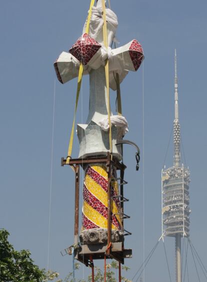 Una grúa eleva la cruz recién restaurada para volver a colocarla en lo alto de la Torre de Bellesguard.