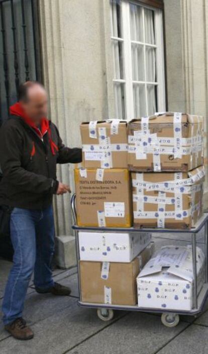 Un policía sale del Ayuntamiento de Ferrol con expedientes administrativos