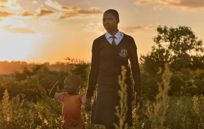 Ángela, de 20 años, camina con su hijo cerca de su casa tras haber acabado las clases en el colegio de Migori, en el oeste de Kenia. Se quedó embarazada después de que uno de sus profesores le ofreciera pagarle las tasas escolares a cambio de sexo. Su padre trató de casarla tras dar a a luz, pero la madre de la adolescente la apoyó para que volviera a estudiar.