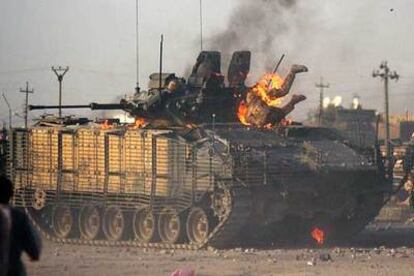 Un soldado británico intenta salir de un vehículo de combate en Basora.