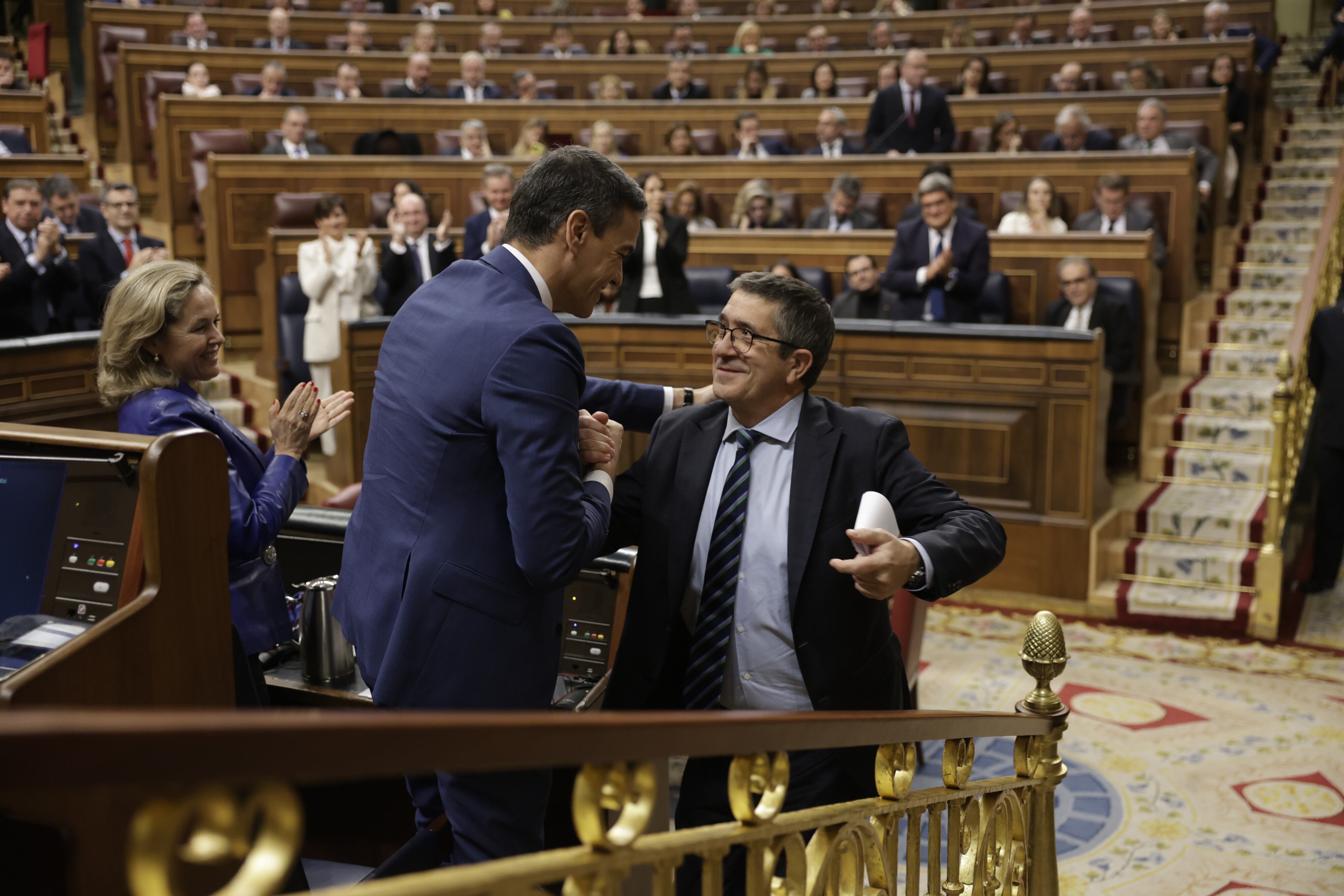 Pedro Sánchez, candidato a la investidura, felicita a Patxi López, portavoz del PSOE en el Congreso, tras su intervención en el debate. 