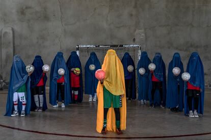 An Afghan women's soccer team poses for a photo in Kabul, Afghanistan, Thursday, Sept. 22, 2022. The ruling Taliban have banned women from sports as well as barring them from most schooling and many realms of work. A number of women posed for an AP photographer for portraits with the equipment of the sports they loved. Though they do not necessarily wear the burqa in regular life, they chose to hide their identities with their burqas because they fear Taliban reprisals and because some of them continue to practice their sports in secret. (AP Photo/Ebrahim Noroozi)