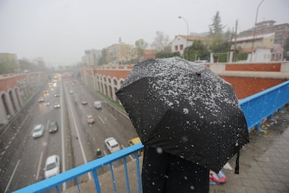 Una mujer observa como nieva sobre la carretera A-2, a la altura de Arturo Soria de Madrid.