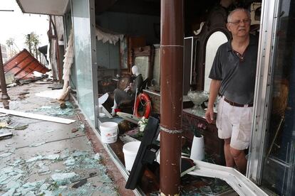 Mike Lindsey trabaja en su tienda de antigüedades después de que los fuertes vientos del huracán Michael destrozaran el lugar.