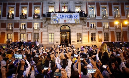 Los jugadores del Real Madrid en el balcón de la sede de la Comunidad de Madrid ante el público congregado en la Puerta del Sol.