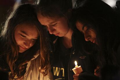 Tres jóvenes recuerdan a las víctimas durantes una vigilia en homenaje a los fallecidos en Newtown.