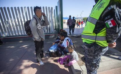 Migrantes en el cruce fronterizo de El Chaparral, en Tijuana, este domingo.