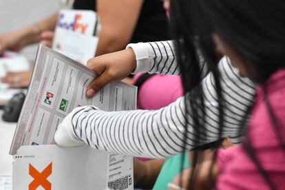 Trabajadoras del INE preparan los Paquetes Electorales Postales que recibirán mexicanas y mexicanos en el extranjero, en Ciudad de México, el 2 de mayo de 2024.