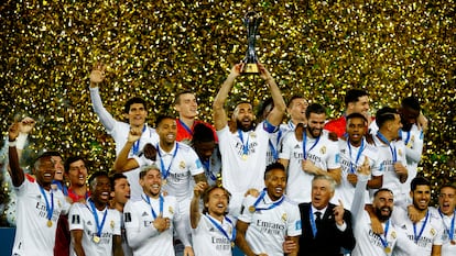 Real Madrid's Karim Benzema lifts the trophy with teammates and coach Carlo Ancelotti after winning the 2023 FIFA Club World Cup final.