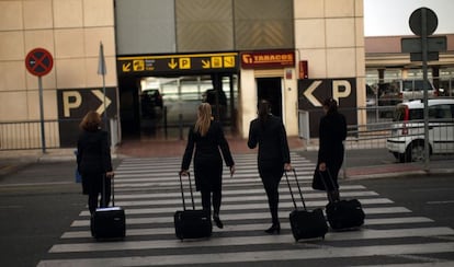 Cuatro azafatas de Vueling acceden a la terminal del aeropuerto de M&aacute;laga.