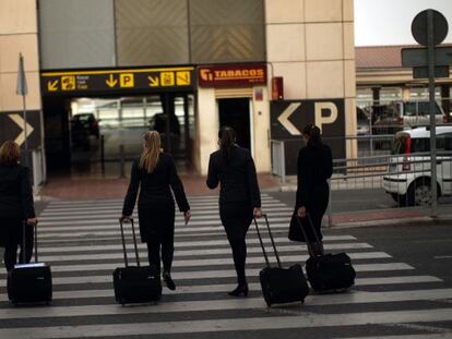 Cuatro azafatas de Vueling acceden a la terminal del aeropuerto de M&aacute;laga.