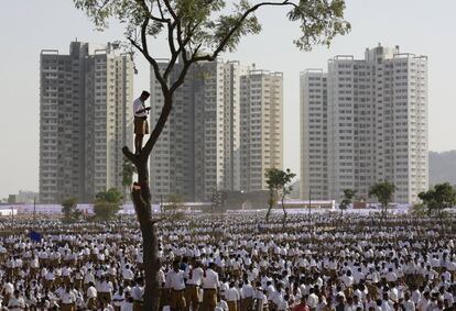 Un voluntario de la organización nacionalista hindú Rashtriya Swayamsevak Sangh (RSS) se encuentra encima de un árbol para asistir a un cónclave en las afueras de Pune (India).