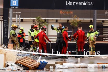 Miembros de los equipos de rescate, a la entrada del parking de Bonaire donde han estado buscando víctimas de la dana, el lunes.