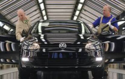 Unos empleados supervisan el acabado de una unidad del Golf 7 de Volkswagen en Alemania. EFE/Archivo