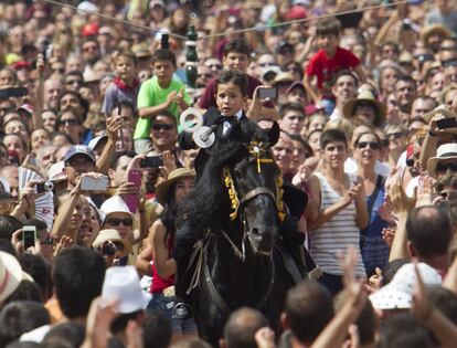 Un joven jinete galopa con una lanza para tratar de desenganchar un anillo durante la tradicional fiesta de San Juan en la localidad de Ciutadella, en Menorca.