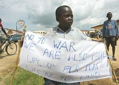 Un niño muestra una pancarta contra la guerra mientras espera la llegada a Bunia de una delegación de la ONU.