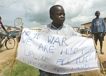 Un niño muestra una pancarta contra la guerra mientras espera la llegada a Bunia de una delegación de la ONU.