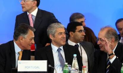 El presidente portugués, Cavaco Silva (izqda.), conversa con el primer ministro, José Sócrates, y el ministro luso de Exteriores, Luis Amado, en la Cumbre Iberoamericana de Estoril, en diciembre de 2009.