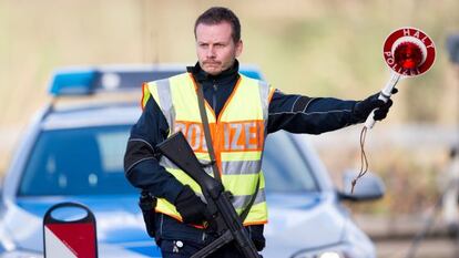 Un policia alemany ordena a un vehicle que s'aturi, a la frontera entre Bèlgica i Holanda.